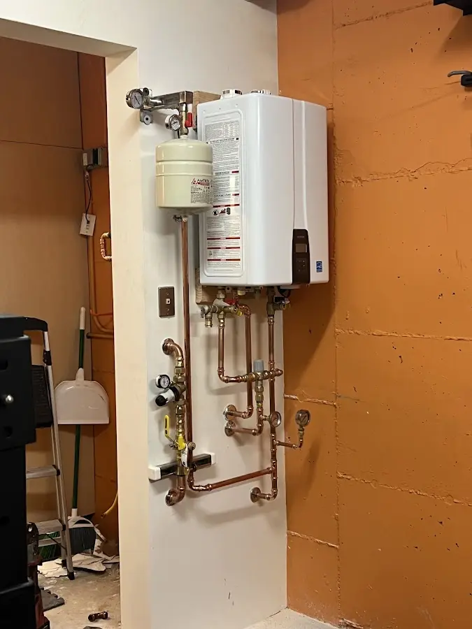 Plumbing technician inspecting water heater connections in Greenwood